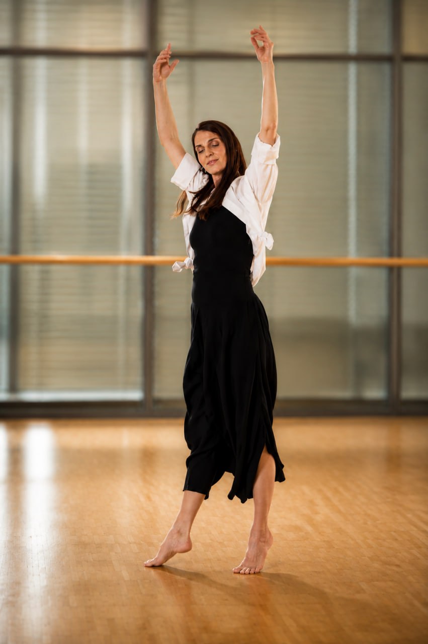 Sylke tanzt auf Zehenspitzen mit erhobenen Armen in einem Tanzstudio