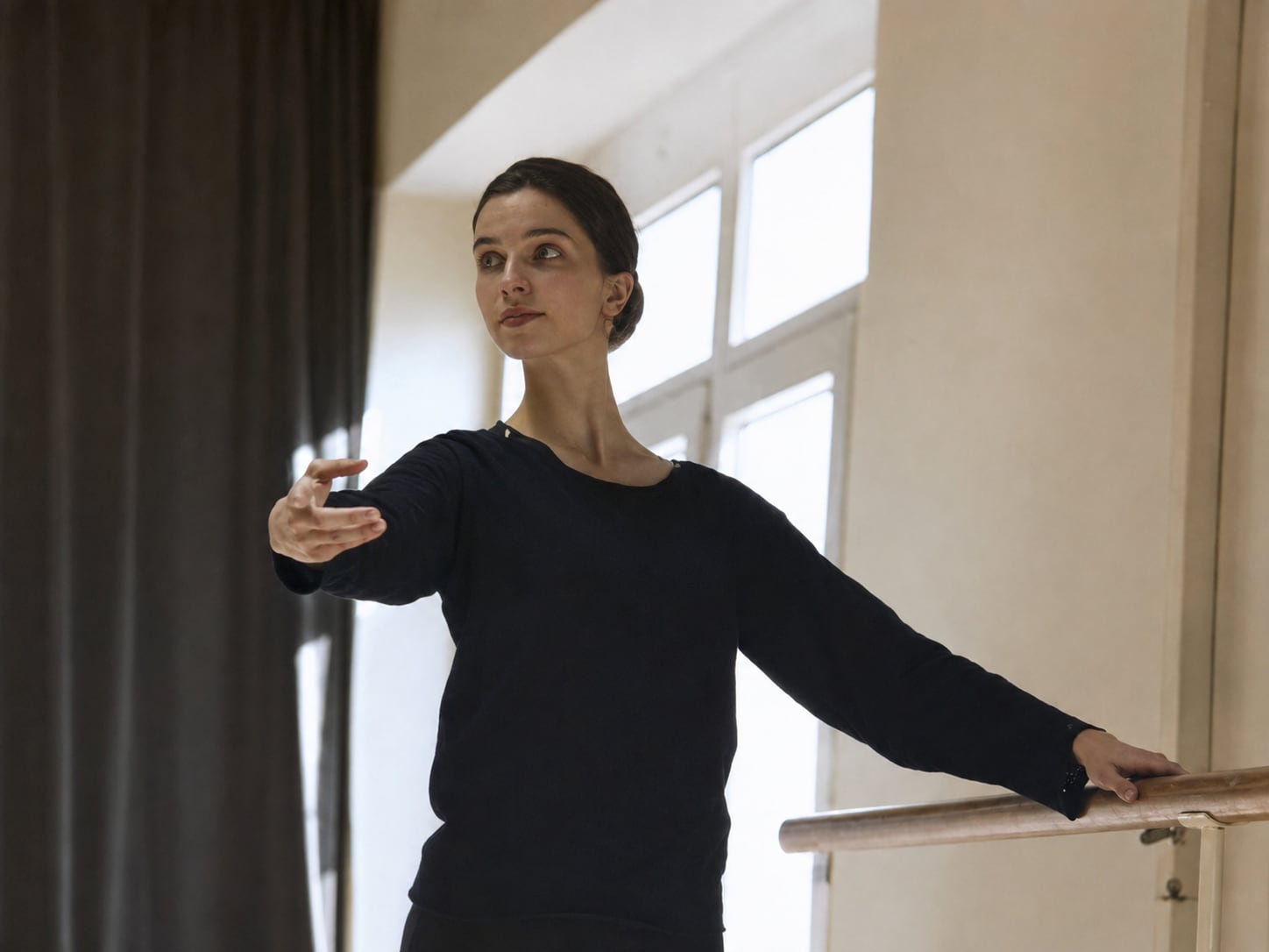 Sylke an der Ballettstange, den Arm zur Seite geöffnet, in einem hellen Saal