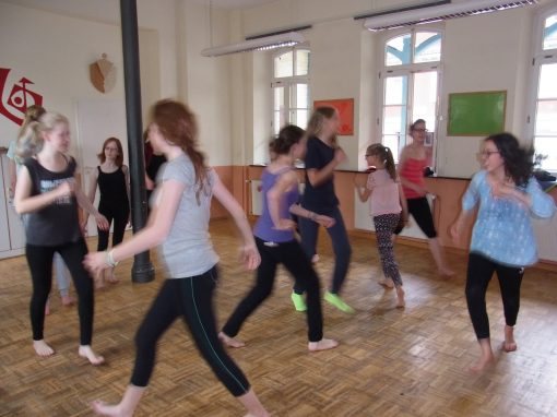 Kinder tanzen barfuß in einem hellen Tanzsaal